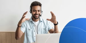 Man wearing headset talking to his laptop with big hand gesture 