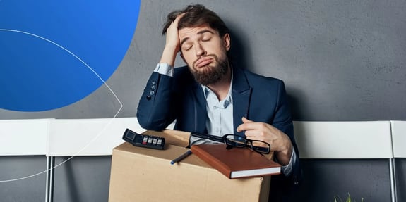 man sitting down closing his eyes looking tired with a box on his lap