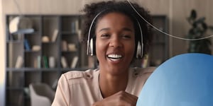 woman wearing headphones smiling into camera