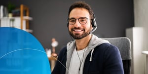 man wearing headsets smiling into camera 
