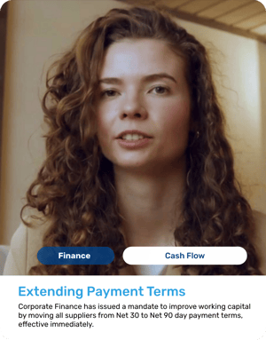 Young woman with long, voluminous curly brown hair, wearing a beige professional blazer. Serious and focused facial expression.